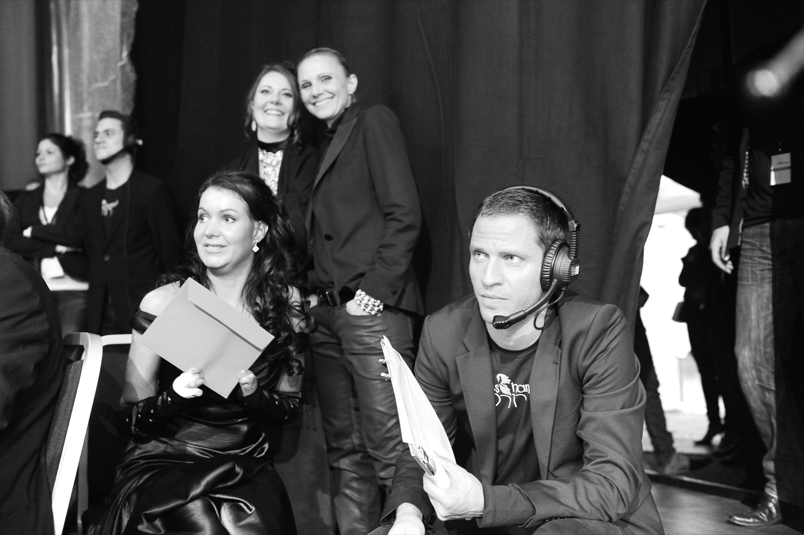 Backstage bei einer Wahlnacht: Michelle Zimmermann sitzt mit einem Couvert in der Hand hinter der Bühne, um sie herum Kolleginnen und Kollegen mit Headsets.